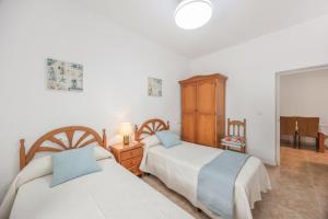 a bedroom with two beds and a mirror at Isabel Casa del Mar in Conil de la Frontera