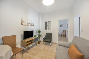 a living room with a couch and a tv at Isabel Casa del Mar in Conil de la Frontera