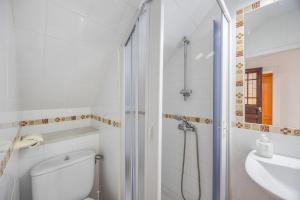 a bathroom with a shower and a toilet and a sink at Isabel Casa del Mar in Conil de la Frontera +15 photos