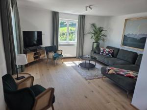 a living room with a couch and a tv at Haus Königsreiter, der besondere Platz in Altmünster
