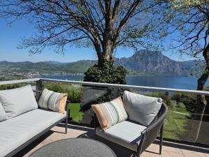 a balcony with two chairs and a view of a lake at Haus Königsreiter, der besondere Platz in Altmünster