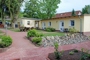a house with a stone wall and a patio at Ferienanlage in Sellin auf Ruegen in Baabe