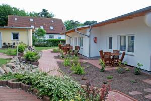 a patio with chairs and tables in a yard at Ferienanlage in Sellin auf Ruegen in Baabe