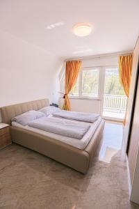 a large bed in a bedroom with a large window at Apartment Baki in Jajce