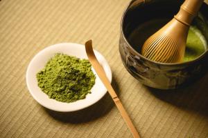 a bowl of green powder and a whisk next to a pot at Shinjuku Washington Hotel in Tokyo