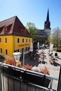 a courtyard with a yellow building and a church at Radebeul Altkötzschenbroda in Radebeul