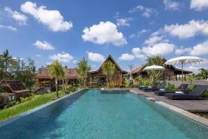 a swimming pool in front of a villa at Berlima Boutique Resort in Ubud