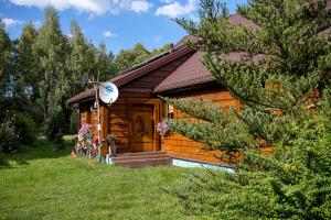 a log cabin with a door in the grass at Agroturystyka na Podlasiu Kraina Puszczyka-Puszczykówka Biebrza, Augustów in Pokośno