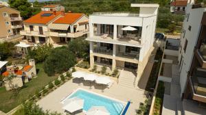 an aerial view of a house with a swimming pool at Kožino Bay Lodge - Brand New Seaside Apartments, Heated Pool in Kožino