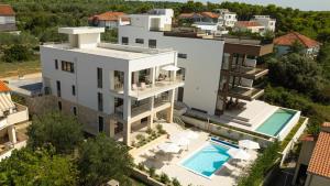 an aerial view of a house with a swimming pool at Kožino Bay Lodge - Brand New Seaside Apartments, Heated Pool in Kožino