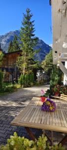 a wooden picnic table with flowers on top of it at Haus am Seebach Leutasch Weidach in Leutasch