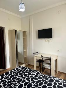 a bedroom with a table and a tv on the wall at Rusalka in Kobuleti