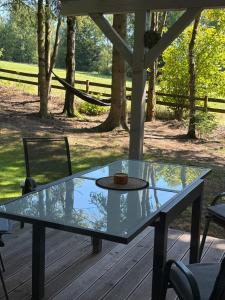 a glass table sitting on a wooden deck at Náš sen - Domek in Svratouch +11 photos
