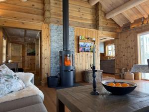 a living room with a stove in a wooden cabin at Cozy Cabin With Ski Trail Access in Beitostøl