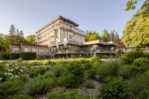 a building with a garden in front of it at LU8 Business Vital Hotel in Bad Dürrheim