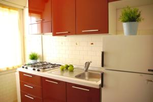 a kitchen with a white refrigerator and a sink at Santis Appartament in Grado