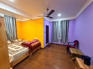 a bedroom with colorful walls and a bed and a table at Sangha Homestay in Dirang Dzong