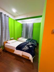 a bedroom with green and orange walls and a bed at Sangha Homestay in Dirang Dzong