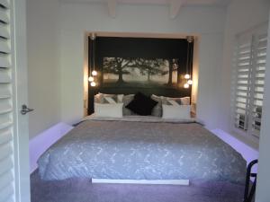 1 dormitorio con 1 cama grande con alfombra morada en Eumundi Yacht Club B&B, en Eumundi