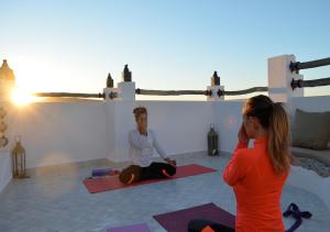 two women are sitting in a yoga class at Munga Guesthouse in Taghazout