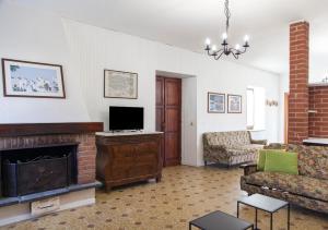 a living room with a fireplace and a tv at La Terrazza sul Giardino in Asti