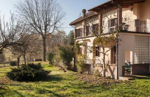 a white house with a yard next to a building at La Terrazza sul Giardino in Asti