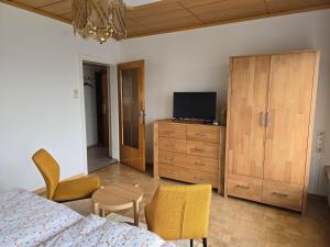 a bedroom with a bed and a dresser and a tv at Ferienwohnungen Knaus in Knittelfeld