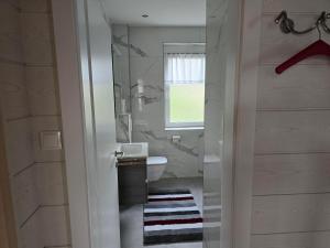 a bathroom with a sink and a toilet and a window at Ferienwohnungen Knaus in Knittelfeld +11 photos