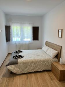 a bedroom with a bed with shoes on it at Eko apartamentos Astelarra in Muxika