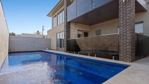 a swimming pool in front of a house at The Coral Esplanade in Mornington