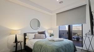 a bedroom with a bed and a mirror and a window at The Coral Esplanade in Mornington +26 photos