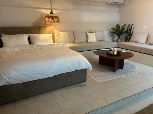 a bedroom with a bed and a couch and a table at Modern & Cozy Studio for 2 in Saronida Steps from the Beach in Saronida