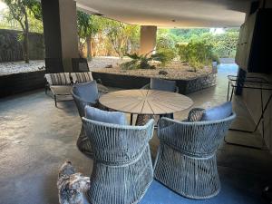 a dog is standing in front of a table and chairs at Modern & Cozy Studio for 2 in Saronida Steps from the Beach in Saronida