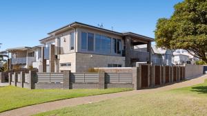 a house with a fence in front of it at The Coral Esplanade in Mornington