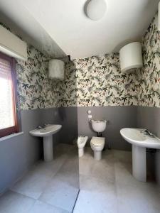 ein Badezimmer mit zwei Waschbecken und einer Toilette in der Unterkunft Sa Spillunca Experience in Làconi