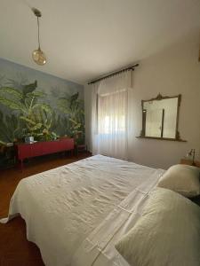 ein Schlafzimmer mit einem großen weißen Bett und einem Spiegel in der Unterkunft Sa Spillunca Experience in Làconi