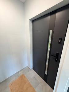 a black door in a room with a rug at Kwiatowy Zakątek na Zaciszu in Radocza