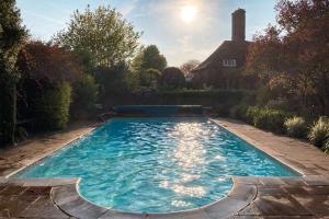 a swimming pool in the yard of a house at The Manor Barn in Canterbury
