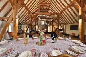 a long table with plates and flowers in a room at The Manor Barn in Canterbury