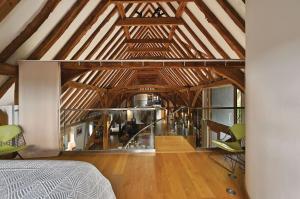 a room with wooden ceilings and a bed and chairs at The Manor Barn in Canterbury +29 photos