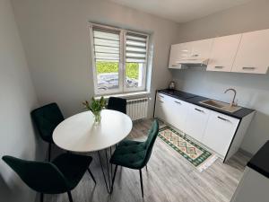 a small kitchen with a table and chairs in a room at Kwiatowy Zakątek na Zaciszu in Radocza