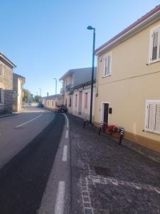 an empty street next to a building with flowers at Oasi Relax Lago Omodeo Casa Demartis in Tadasuni