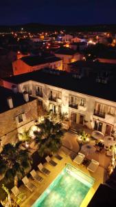 a building with a swimming pool with chairs and a building at Jardin d'Azur Alaçatı in Alaçatı