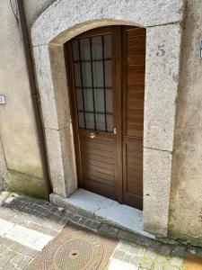 a large wooden door in a stone building at IL CASTAGNETO Room in Pietraroia