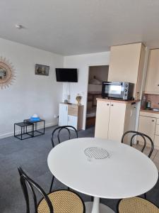 a room with a table and chairs and a kitchen at Studio avec balcon, 4 personnes in Quiberon