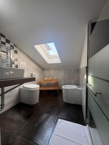 a bathroom with two toilets and a sink and a skylight at B&B Residenza Leonardo in Falconara Marittima +29 photos