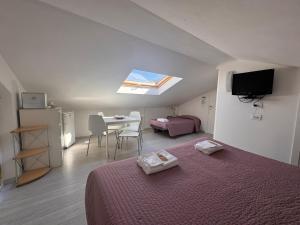 a bedroom with a bed and a table and a tv at B&B Residenza Leonardo in Falconara Marittima