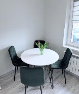 a white table with four chairs and a vase of flowers at Kwiatowy Zakątek na Zaciszu in Radocza +32 photos