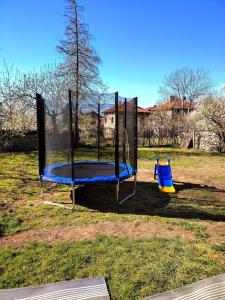 a playground with a swing set in a park at Guest House Emiliya in Ovchartsi
