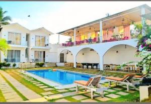 a villa with a swimming pool and a house at Tvessa-A Boutiqe Hotel in Mandrem